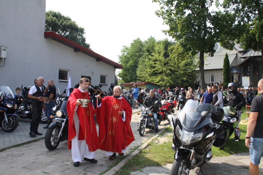  Enlarge Image 	Ksiądz w czerwonej sutannie dokonuje poświęcenia motocykli stojących na dworze 