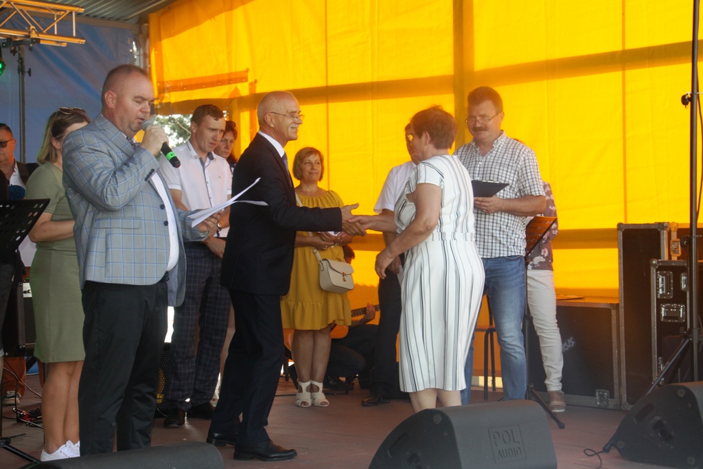 Wręczenie nagrody przez burmistrza, na scene burmistrz, osoba odbierająca nagrodę, prowadzący oraz inne osoby