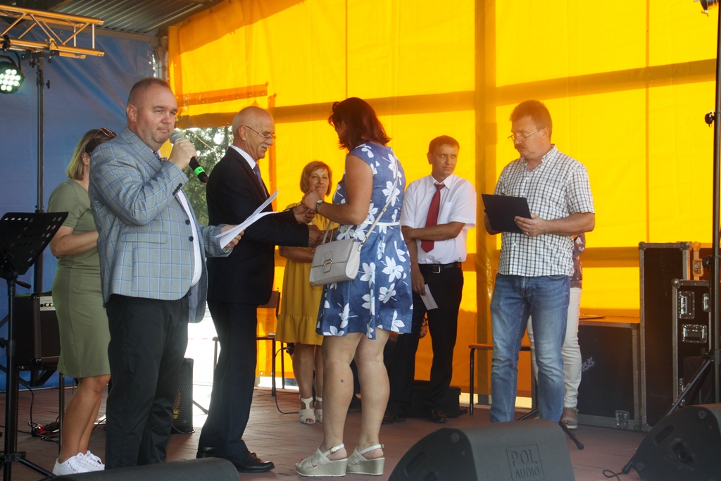 Wręczenie nagrody przez burmistrza, na scene burmistrz, osoba odbierająca nagrodę, prowadzący oraz inne osoby